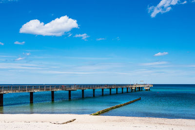 Pier over sea against blue sky