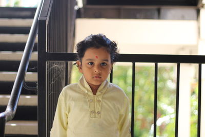 Close-up portrait of boy against railing