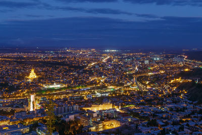 High angle view of illuminated city against sky at night