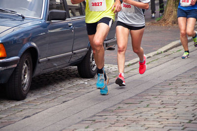 Low section of athletes running marathon on street