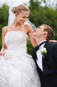 Portrait of bride and bridegroom standing in park