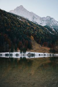 Scenic view of lake by mountains against sky