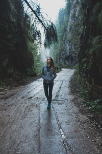 Woman walking on footpath in forest
