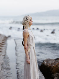 Portrait of young woman standing at beach