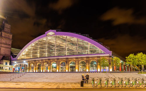 People on illuminated bridge at night
