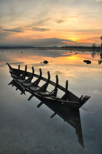 Scenic view of boat in sea at sunset