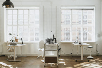 Empty corporate office with computers on desk near window