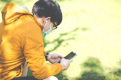 Midsection of man using mobile phone outdoors