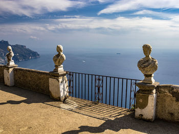 Statue by sea against sky