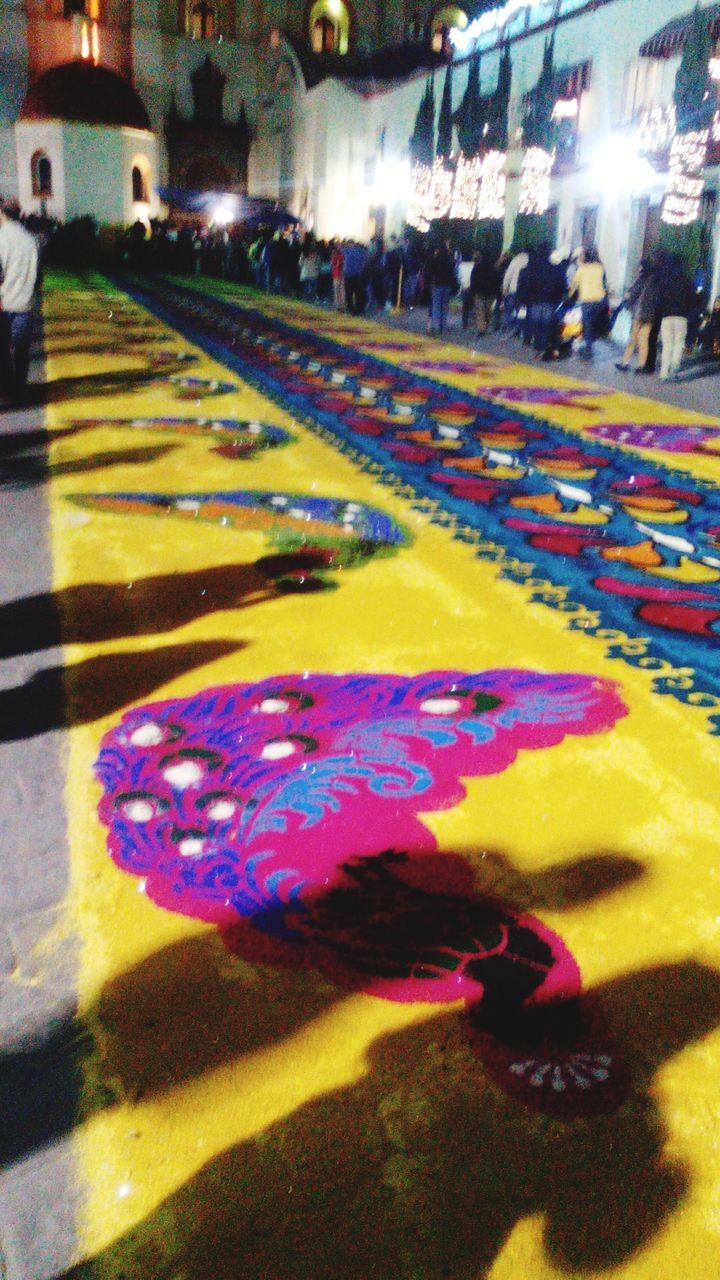 multi colored, street, illuminated, night, incidental people, large group of people, city, celebration, high angle view, outdoors, art, art and craft, city life, colorful, road, motion, creativity, leisure activity, city street