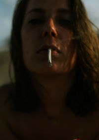 Close-up portrait of woman smoking cigarette