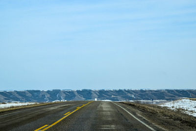 Road against clear blue sky