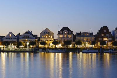 Germany, schleswig-holstein, lubeck, row of riverside villas at dusk