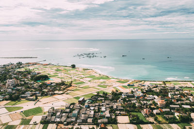 High angle view of townscape by sea against sky