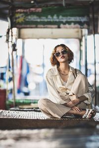 Portrait of young woman wearing sunglasses sitting on swing