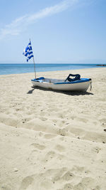 Deck chairs on beach against sky