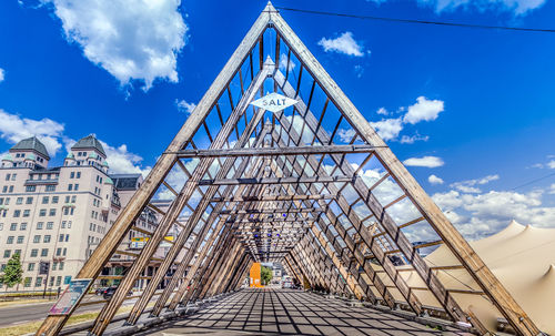 Low angle view of footbridge against cloudy sky