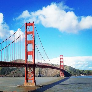 View of suspension bridge against cloudy sky