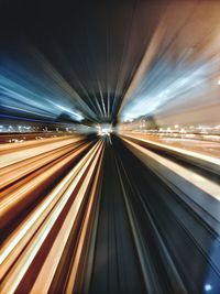 Light trails on railroad station against sky at night