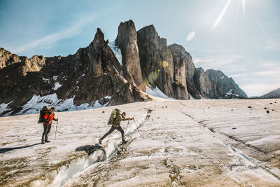 People on snowcapped mountain against sky