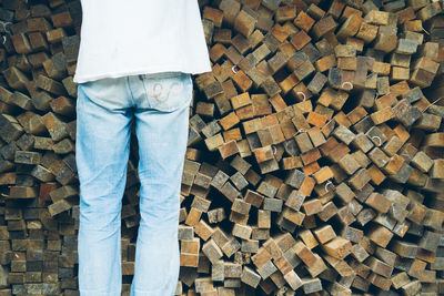 Person standing by wood stack