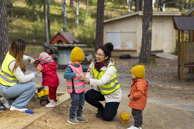 Preschool teachers with students at playground