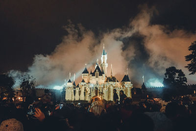 Panoramic view of crowd at illuminated buildings against sky at night