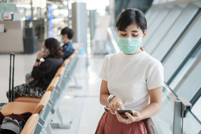 Rear view of woman holding mobile phone