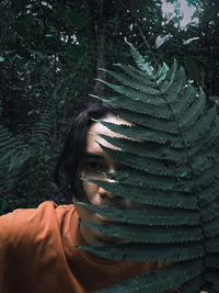 Portrait of young woman against trees