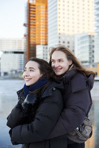 Smiling female couple in modern neighborhood