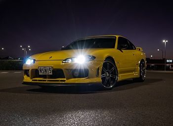 Yellow car on street at night