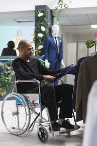 Rear view of man sitting on wheelchair