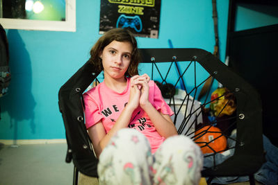 Teen girl clasps hands together while sitting in a bungee chair