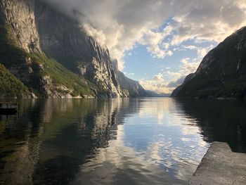 Scenic view of lake by mountains against sky