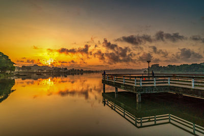 Pier over lake against sky during sunset