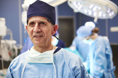 Smiling doctor looking away while standing in hospital