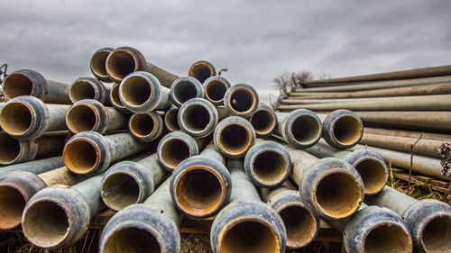 Stack of pipes against sky