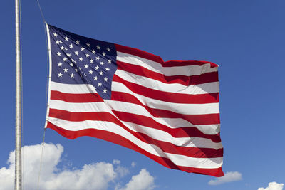 Low angle view of flag against blue sky