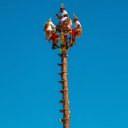 Low angle view of communications tower against clear blue sky