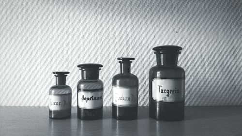Medicine bottles on table against wall