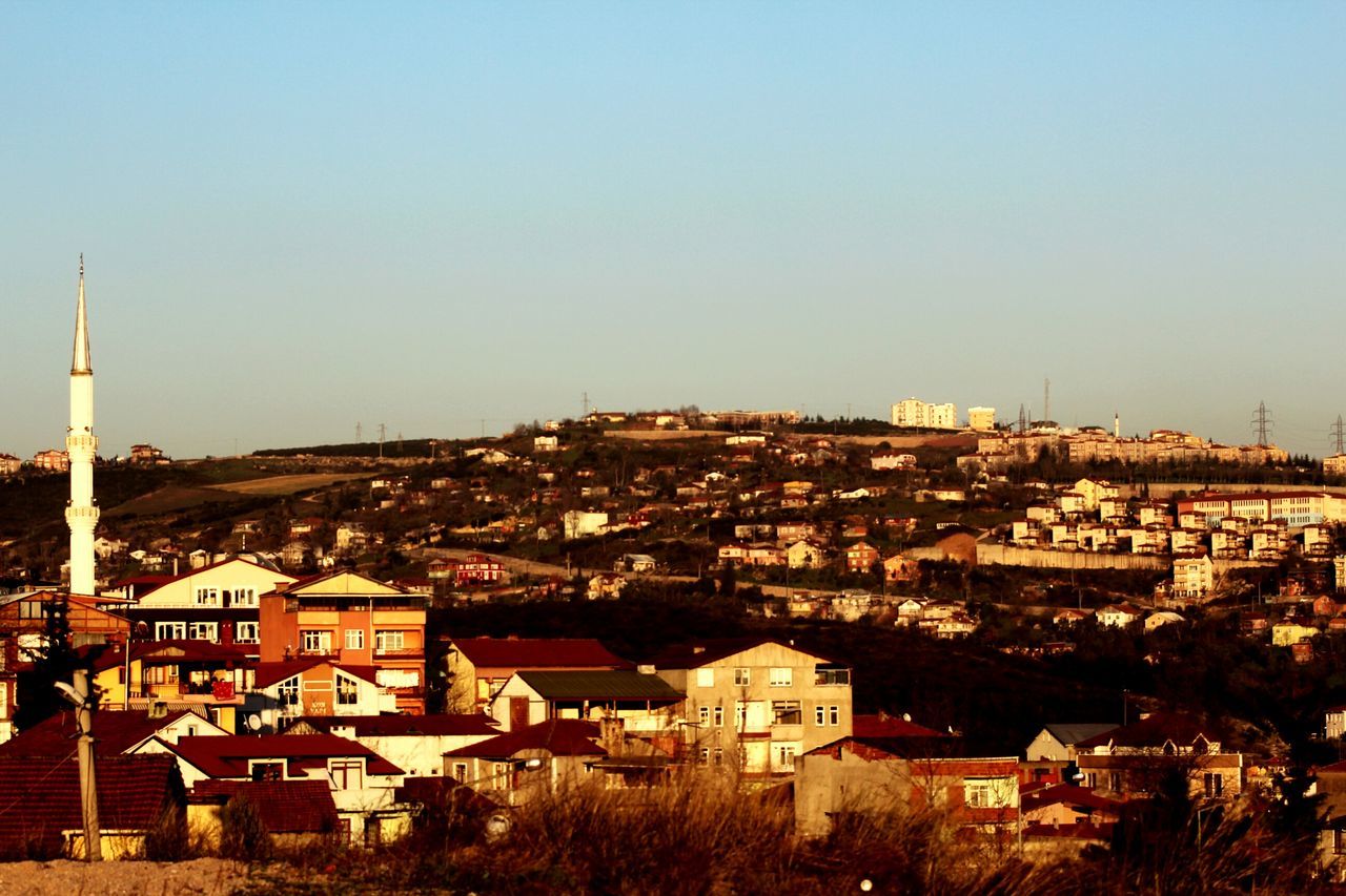 building exterior, architecture, built structure, clear sky, copy space, residential district, residential structure, cityscape, house, residential building, city, high angle view, crowded, town, townscape, roof, blue, tree, tower, outdoors