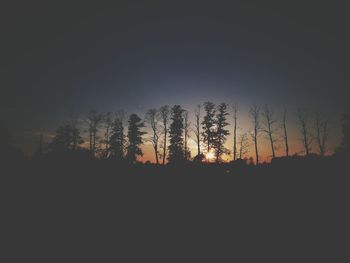 Silhouette trees on landscape against clear sky