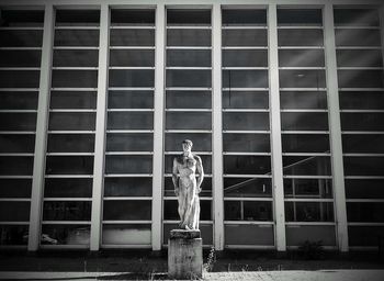 Statue of man standing outside building