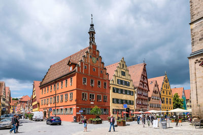 Buildings in city against cloudy sky