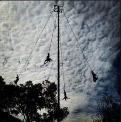 Low angle view of airplane flying in cloudy sky