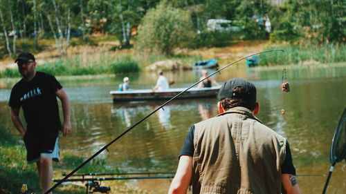 Rear view of man fishing in lake