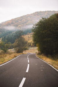 Road amidst trees against sky
