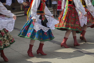 Low section of people walking on street in city