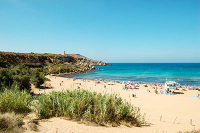 Scenic view of beach against clear blue sky