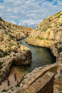 High angle view of river amidst rock formations against sky
